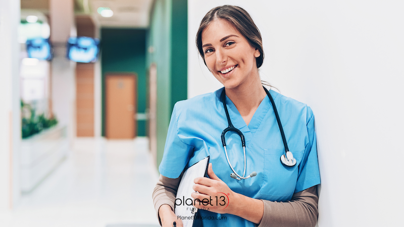 Smiling female healthcare professional wearing blue scrubs and a headset.