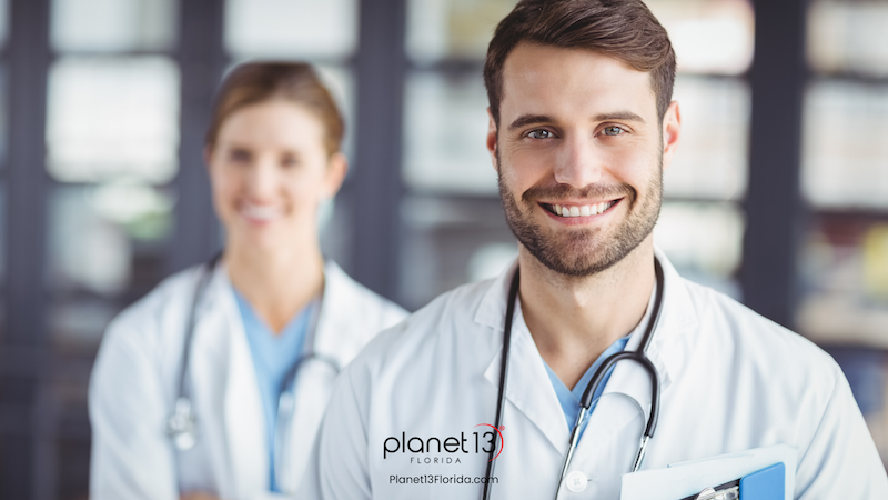 Smiling male doctor standing in a bright medical office.