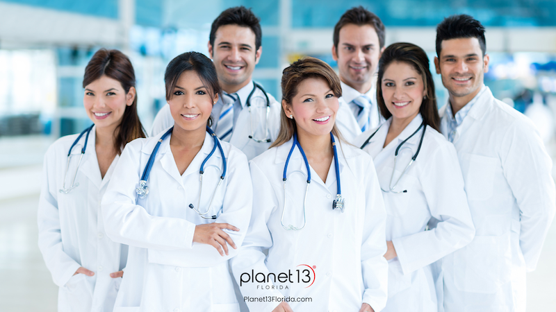 Large group of smiling doctors and nurses standing together.