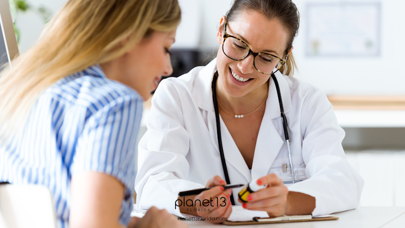 Female doctor smiling while speaking with a patient during an appointment.
