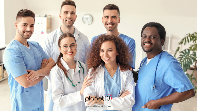 Group of smiling healthcare professionals standing together in a clinic.