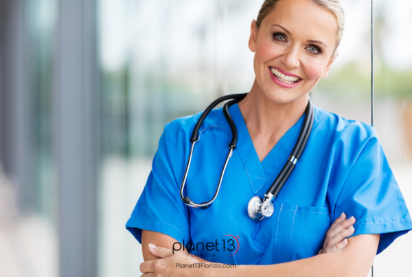 Smiling female healthcare professional wearing bright blue scrubs.
