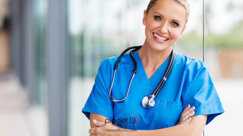 Smiling female healthcare professional wearing bright blue scrubs.