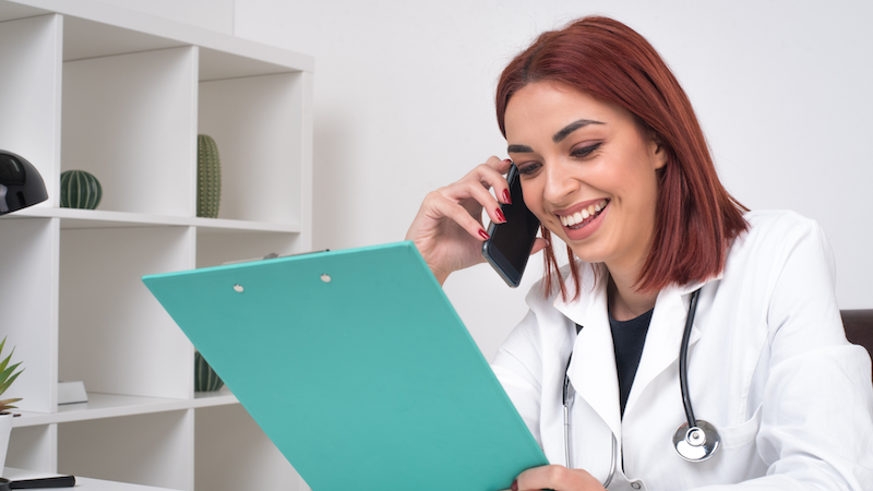 Female healthcare professional wearing a headset while speaking on the phone.