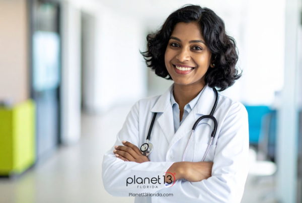Female doctor wearing a white coat and stethoscope in a bright medical office.